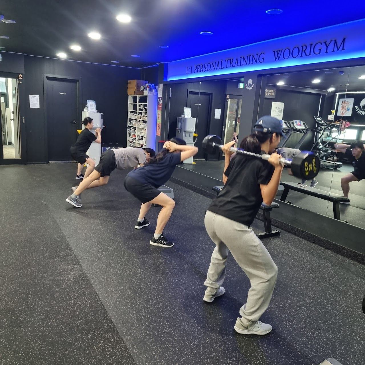 우리짐에서 회원들이 바벨 스쿼트로 자유운동을 하는 모습
